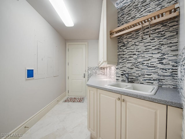 kitchen featuring tasteful backsplash, cream cabinets, and sink