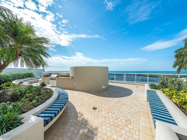 view of patio / terrace featuring an outdoor kitchen and a water view