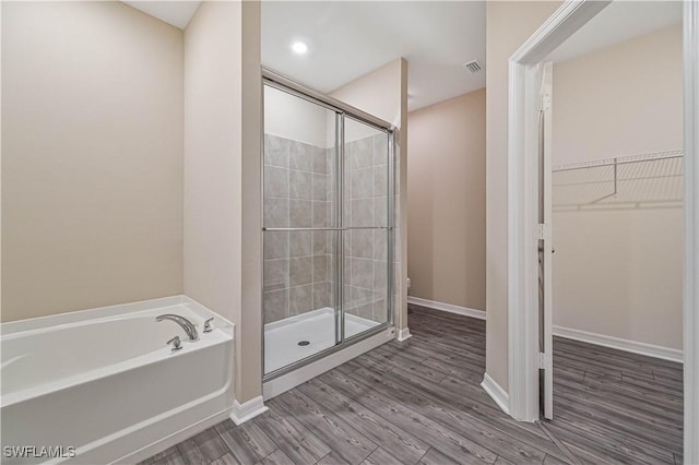 bathroom featuring separate shower and tub and wood-type flooring