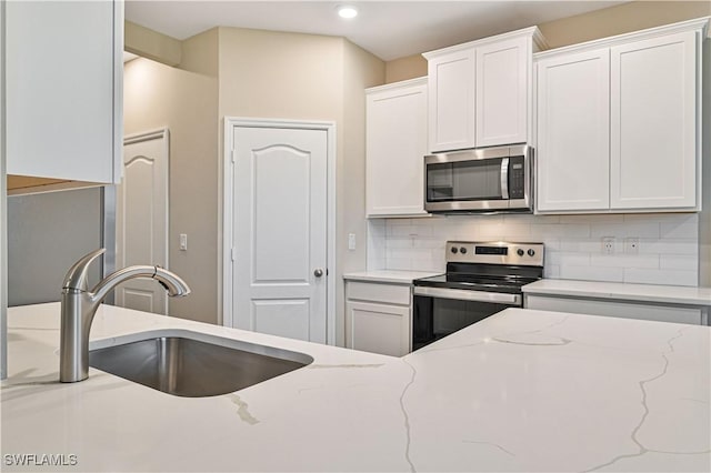 kitchen with white cabinets, appliances with stainless steel finishes, and sink