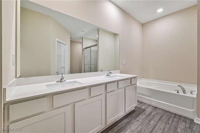 bathroom with vanity, wood-type flooring, and independent shower and bath