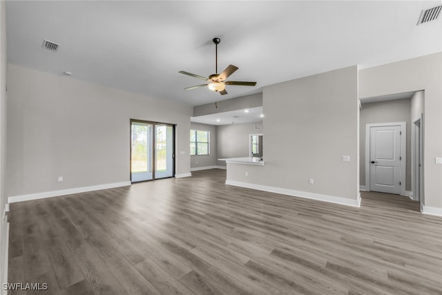 unfurnished living room featuring a ceiling fan, wood finished floors, baseboards, and recessed lighting