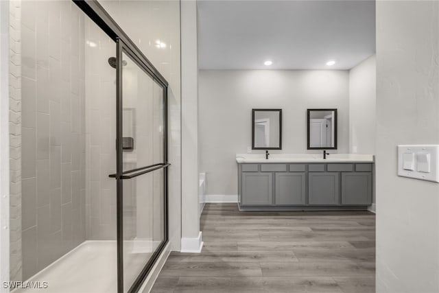 full bath with a shower stall, a garden tub, wood finished floors, double vanity, and recessed lighting
