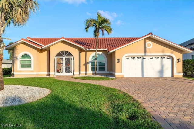 mediterranean / spanish home with a front lawn and a garage