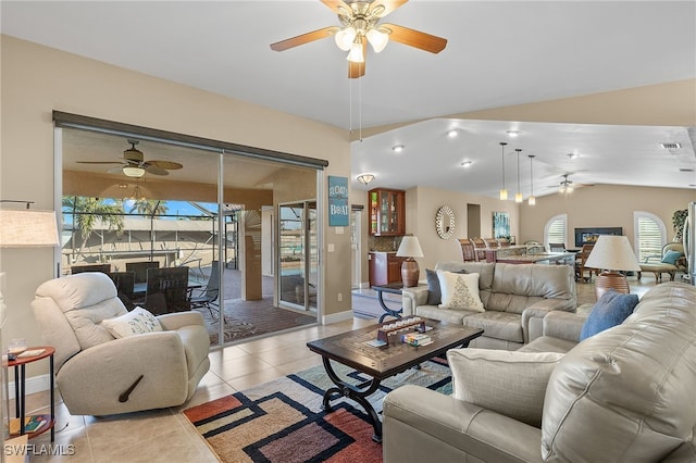 living room with light tile patterned flooring, ceiling fan, and vaulted ceiling