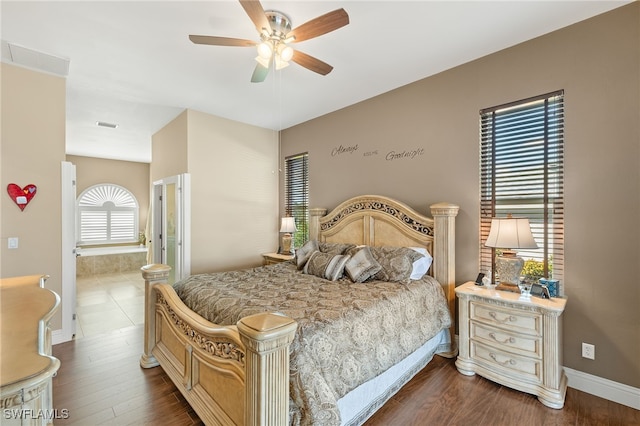 bedroom featuring ensuite bathroom, dark hardwood / wood-style flooring, and ceiling fan