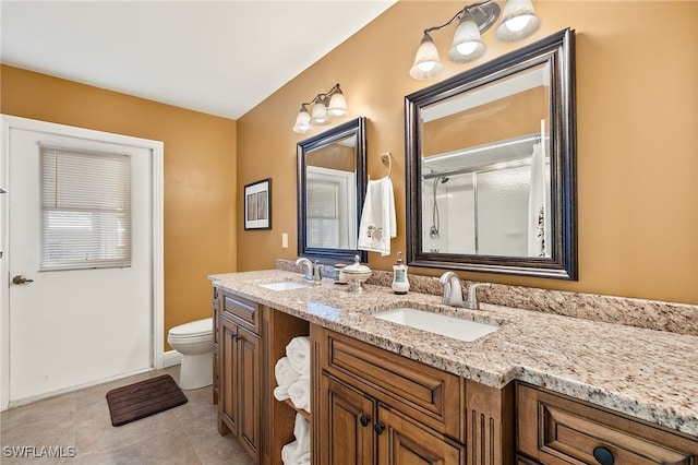 bathroom with toilet, vanity, tile patterned floors, and a shower with shower door