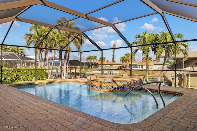 view of swimming pool featuring glass enclosure and an in ground hot tub