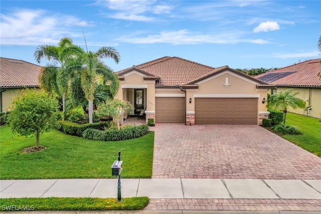 mediterranean / spanish home with a garage and a front lawn