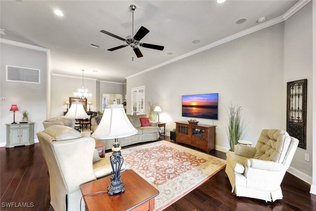 living room with dark wood-type flooring, crown molding, and ceiling fan with notable chandelier