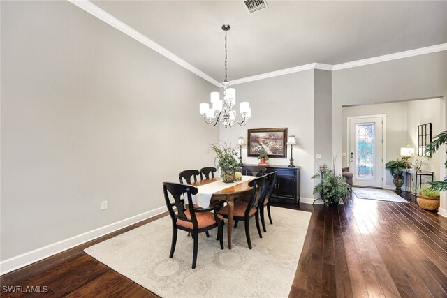 dining room with crown molding, dark wood-type flooring, and a chandelier