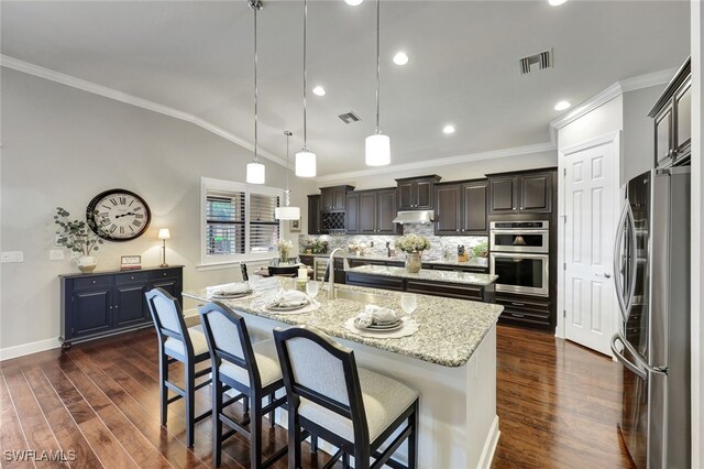 kitchen featuring an island with sink, sink, dark hardwood / wood-style flooring, hanging light fixtures, and stainless steel appliances