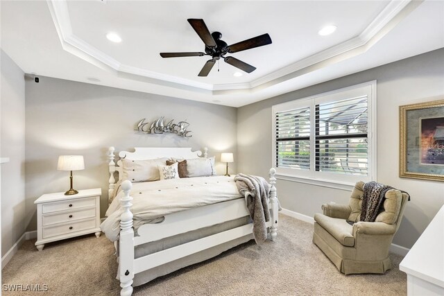 carpeted bedroom with a raised ceiling, crown molding, and ceiling fan