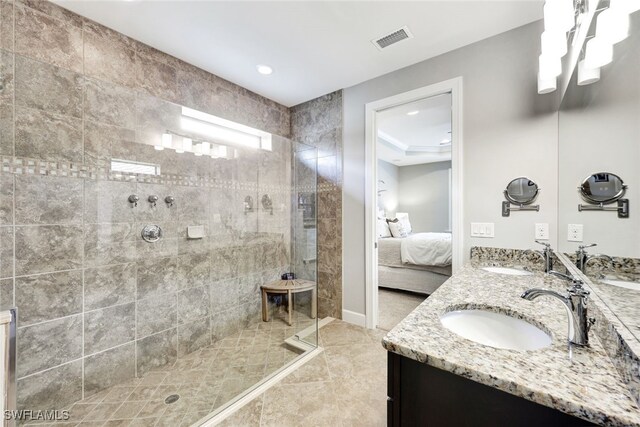 bathroom featuring vanity, tile patterned floors, and tiled shower