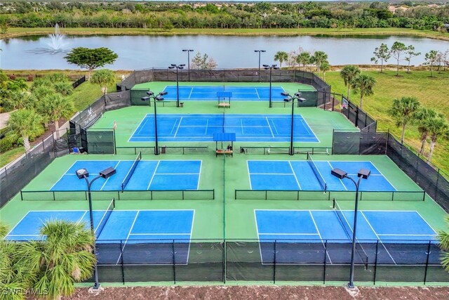 view of tennis court with a water view