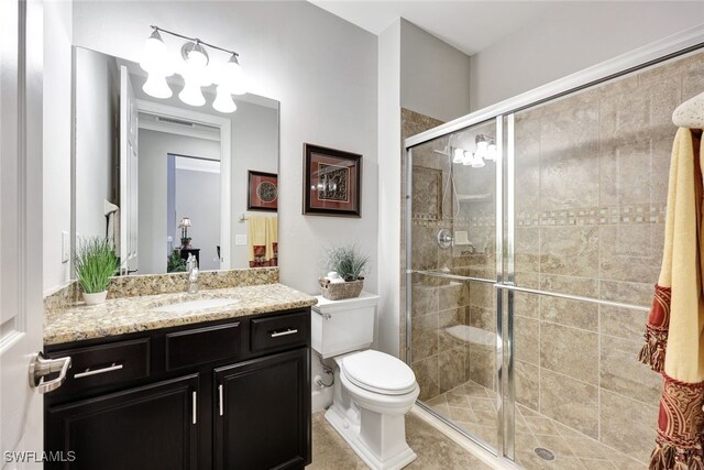 bathroom featuring vanity, a shower with door, and toilet