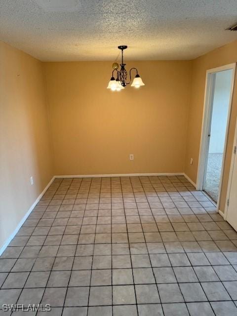 tiled empty room with an inviting chandelier