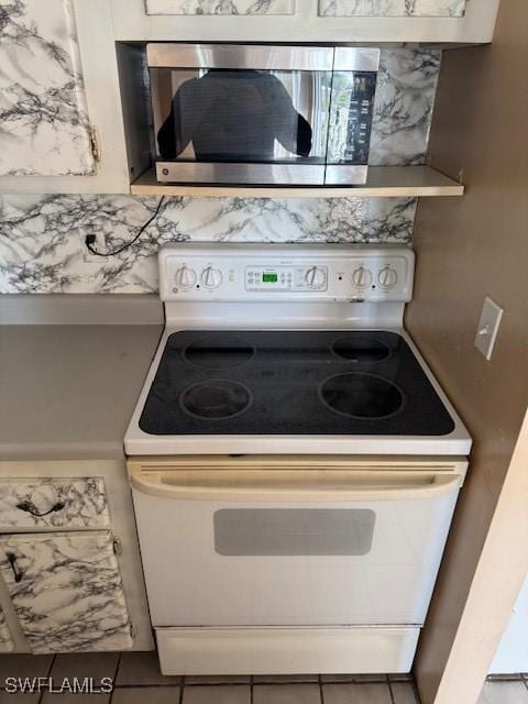 kitchen featuring tile patterned floors and white range with electric stovetop