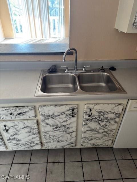 interior details with sink, white cabinets, and white dishwasher