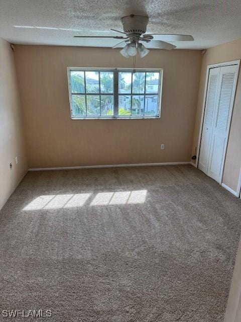 unfurnished bedroom with a textured ceiling, carpet floors, and ceiling fan