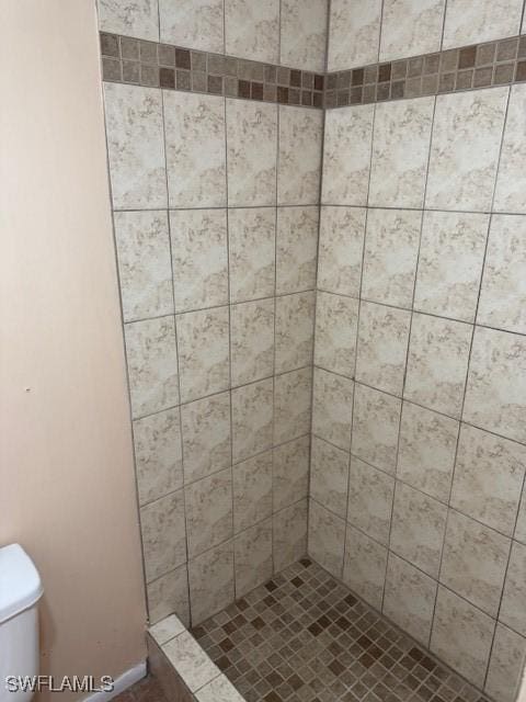 bathroom with toilet and tiled shower