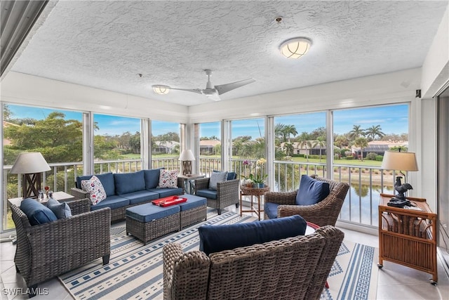 sunroom / solarium with ceiling fan, a water view, and a wealth of natural light