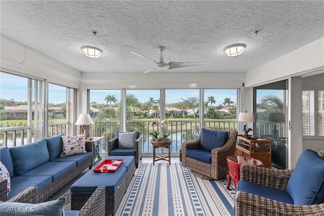 sunroom / solarium with a wealth of natural light, a water view, and ceiling fan