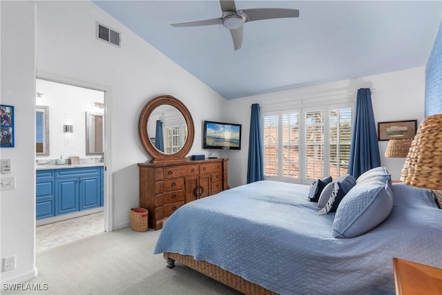 carpeted bedroom featuring ensuite bath, ceiling fan, and lofted ceiling