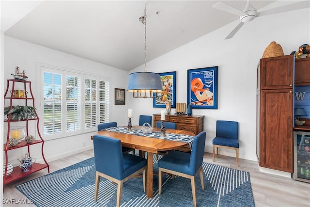 dining space featuring light hardwood / wood-style floors, vaulted ceiling, beverage cooler, and ceiling fan