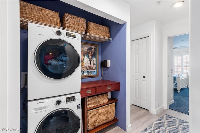 laundry area featuring light wood-type flooring and stacked washer and clothes dryer