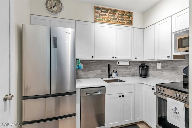 kitchen with decorative backsplash, white cabinetry, sink, and stainless steel appliances