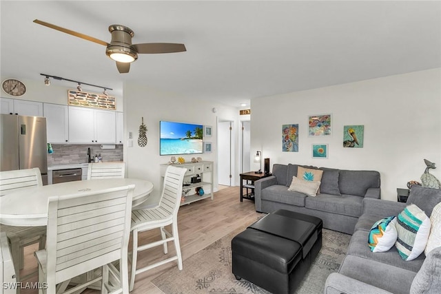 living room with light hardwood / wood-style floors and ceiling fan