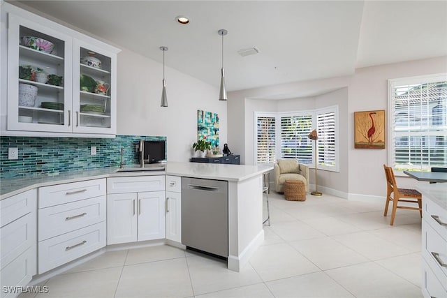 kitchen featuring dishwasher, white cabinetry, tasteful backsplash, decorative light fixtures, and kitchen peninsula