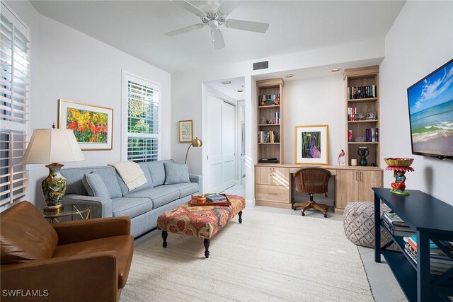 living room featuring built in features and ceiling fan