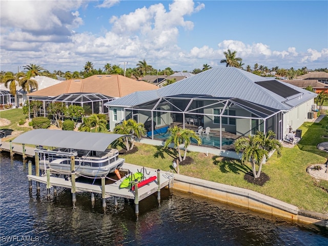 view of dock featuring a lanai, a lawn, and a water view