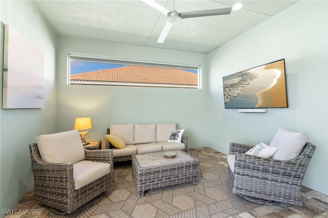 living room featuring ceiling fan, plenty of natural light, and a textured ceiling