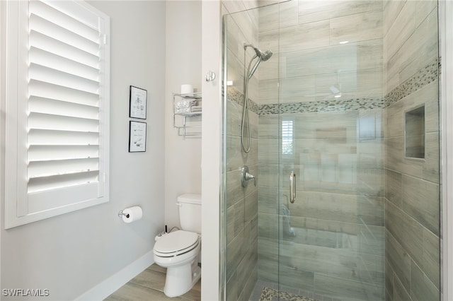 bathroom featuring walk in shower and toilet