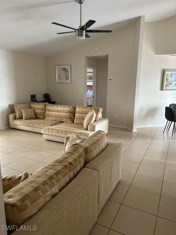 tiled living room with ceiling fan and lofted ceiling