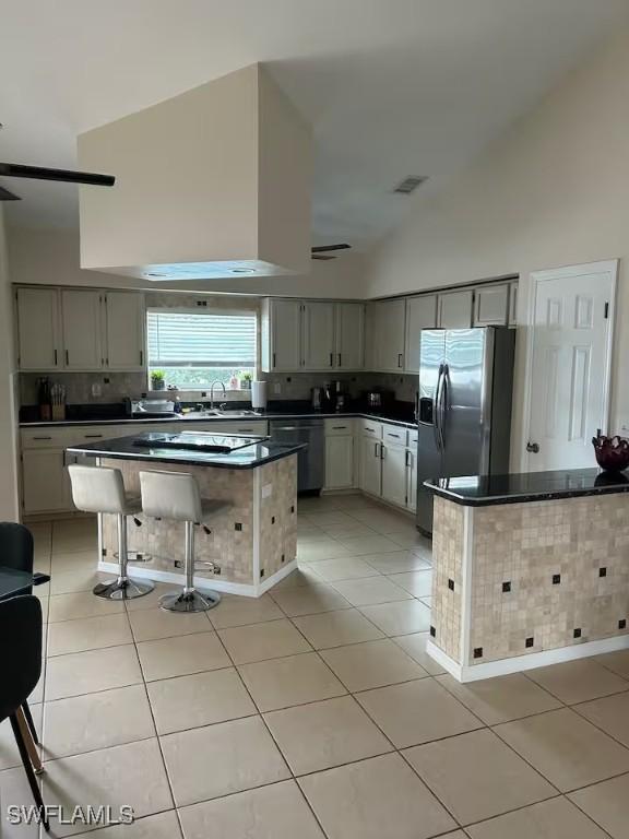 kitchen with gray cabinets, stainless steel fridge, dishwasher, and light tile patterned flooring