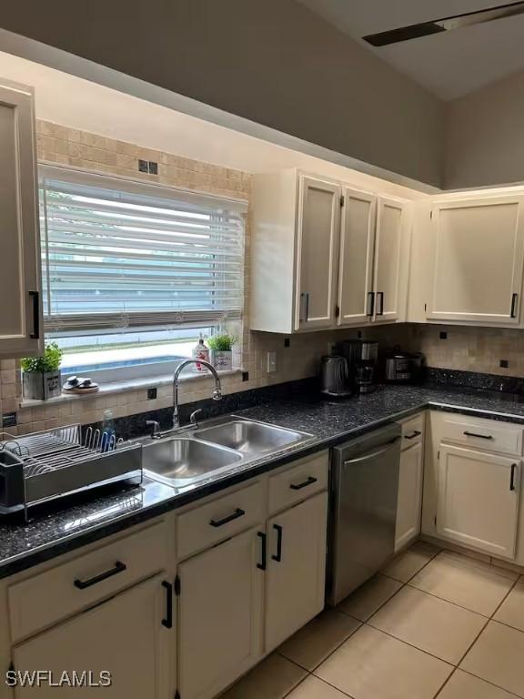 kitchen featuring white cabinetry, sink, light tile patterned floors, and stainless steel dishwasher