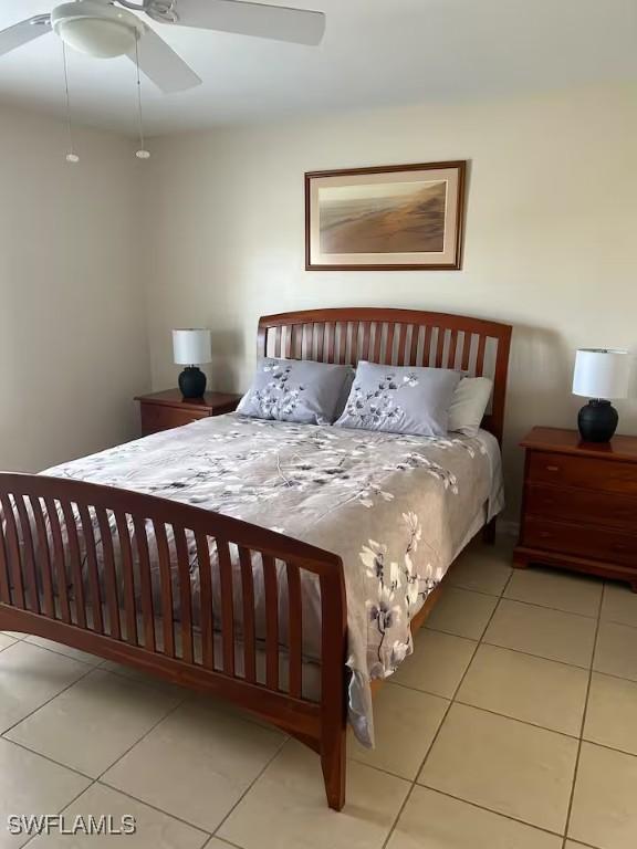 tiled bedroom featuring ceiling fan