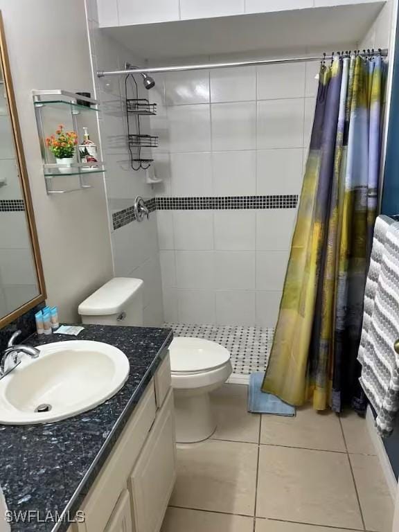 bathroom with tile patterned flooring, vanity, curtained shower, and toilet