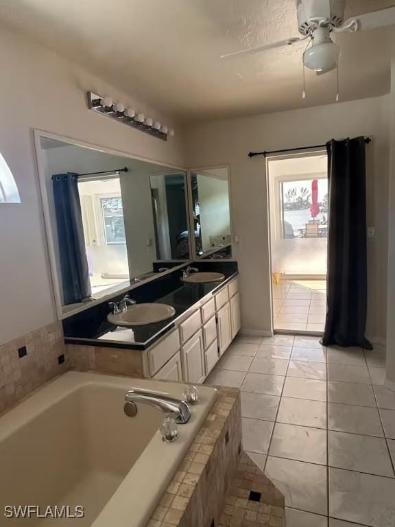 bathroom with vanity, ceiling fan, tile patterned flooring, and a relaxing tiled tub