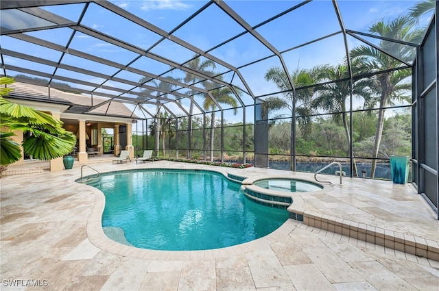 view of pool with a lanai, a patio area, and an in ground hot tub