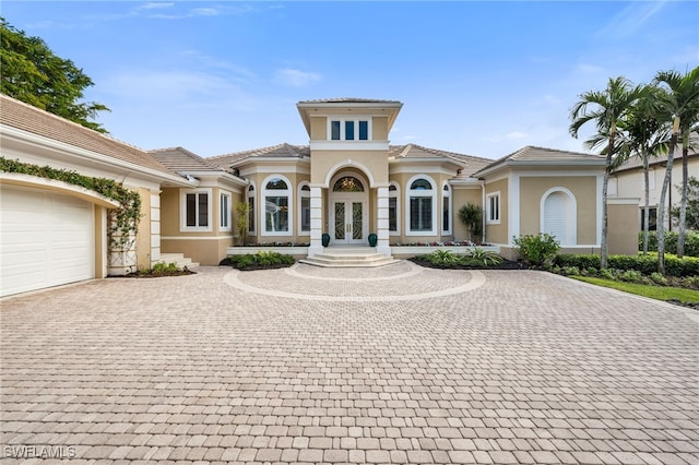 mediterranean / spanish house with french doors and a garage