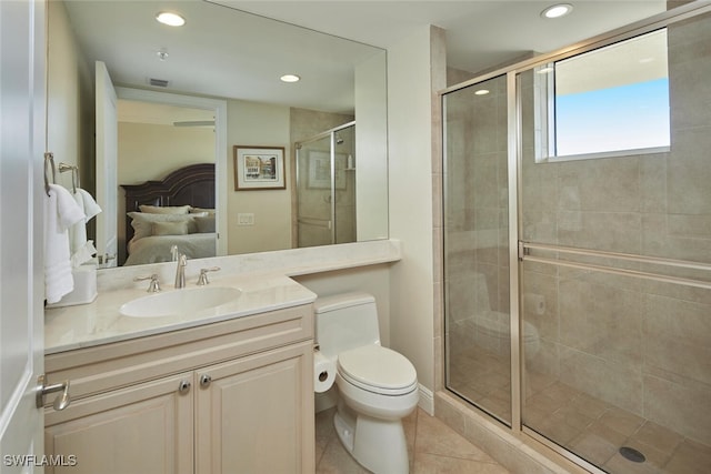 bathroom featuring tile patterned floors, vanity, toilet, and a shower with door