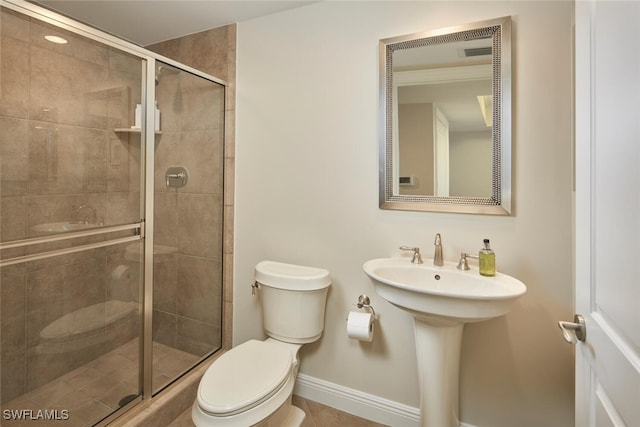 bathroom featuring sink, an enclosed shower, and toilet