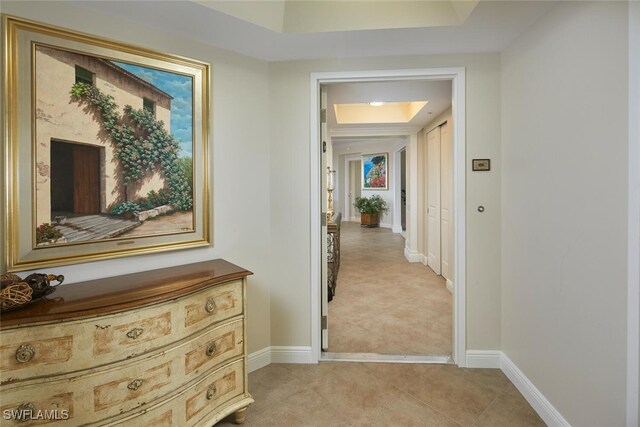 23850 Via Italia Cir Unit 406, Estero, FL 34134 - hall with a tray ceiling, baseboards, and light tile patterned flooring