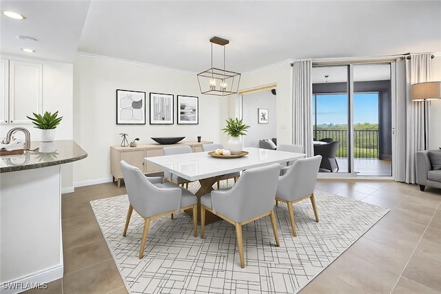 dining space featuring baseboards, ornamental molding, a chandelier, and tile patterned floors