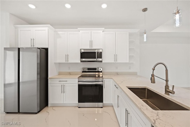 kitchen featuring light stone countertops, stainless steel appliances, sink, pendant lighting, and white cabinetry